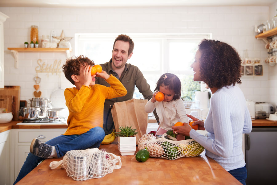 Family happily unpacking groceries together