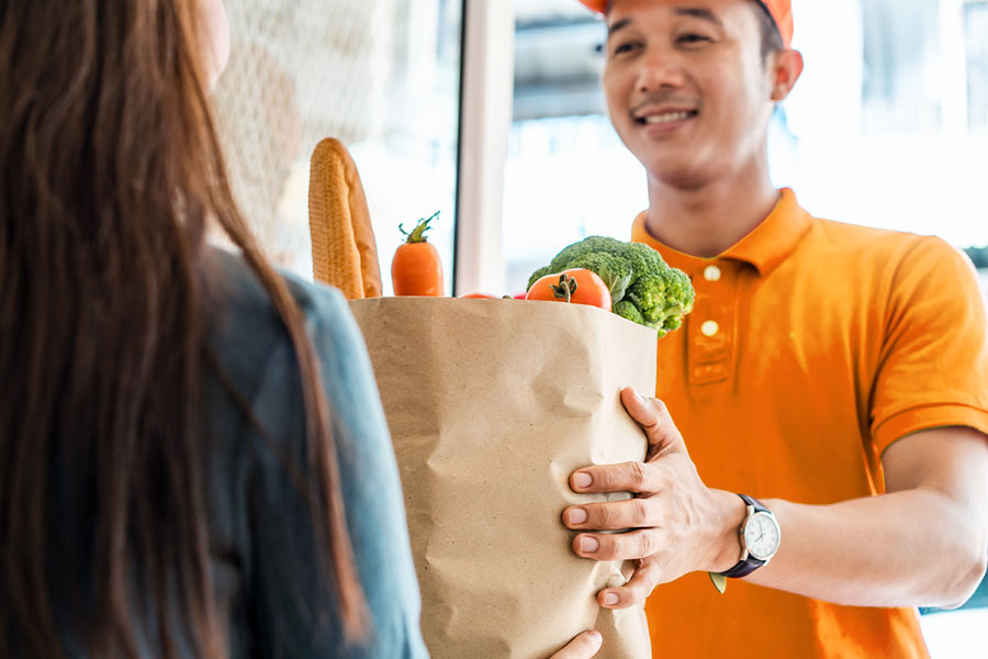 A woman accepting grocery delivery at home