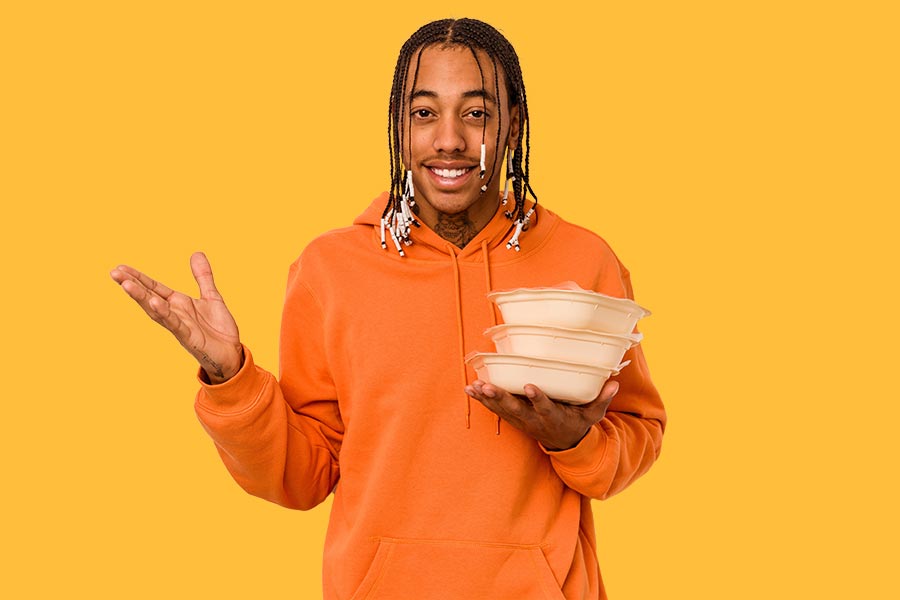 Smiling man holding leftovers in Tupperware containers